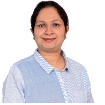 Group of construction workers with one worker in the foreground smiling and wearing a white hard hat.